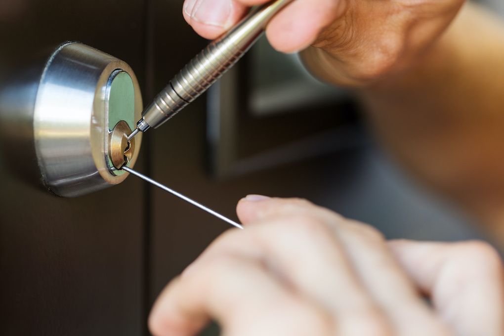 Locksmith opening a door lock with picking tools